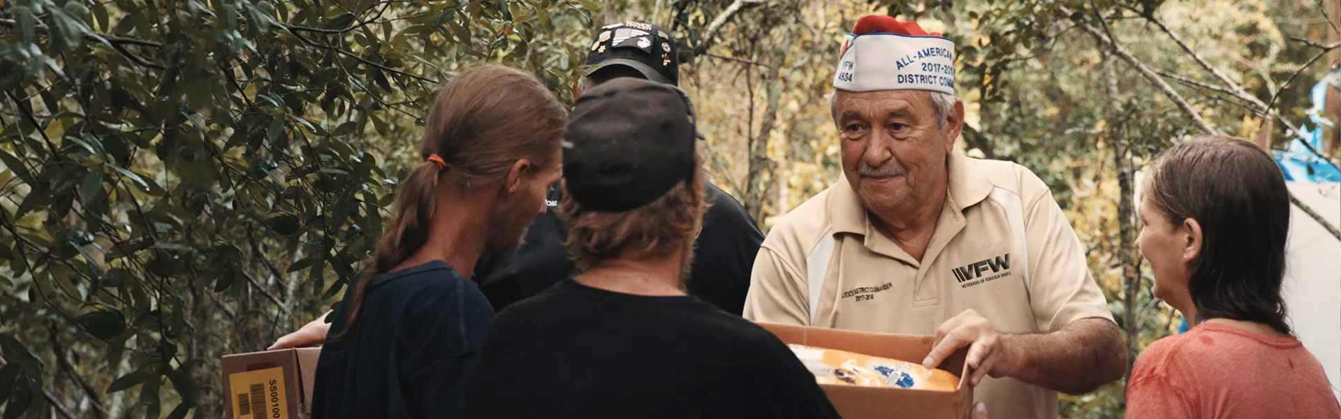 VFW member passing out supplies to veterans during a community drive.