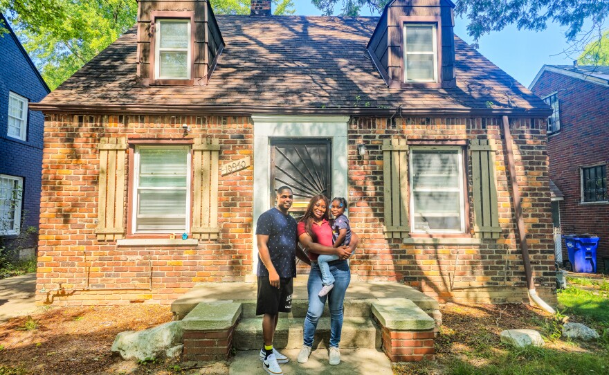 Veterans D’Andre and Erica with their daughter Minty in front of their new home, supported by Volunteers of America Michigan.
